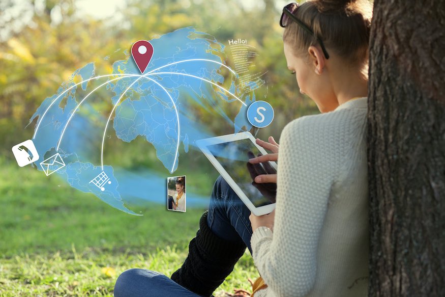 Concept of sitting young woman using her tablet pc during rest in the park